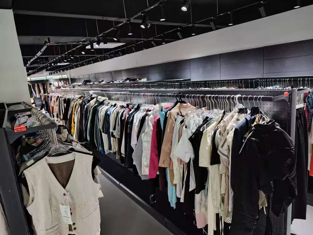 TaoGo Mart: Rows of Affordable Fashion & Wedding Dresses - Surelah.com - SureLah.com Interior view of TaoGo Mart warehouse showing long aisles of clothing racks, customers browsing, and the viral affordable wedding dress section.